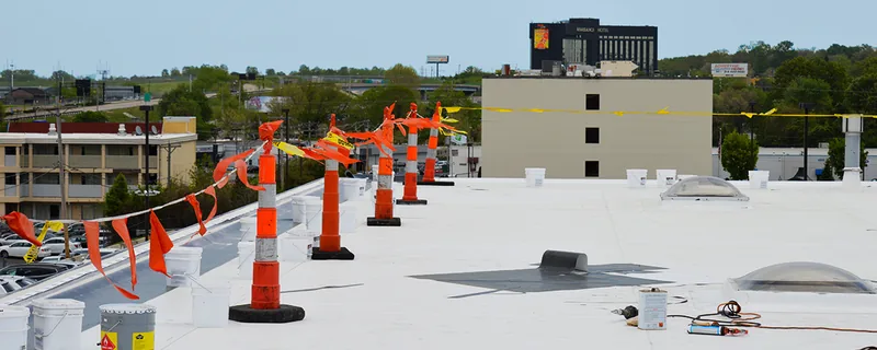 Flat commercial roof with ventilation equipment and safety cones — John Beal Roofing