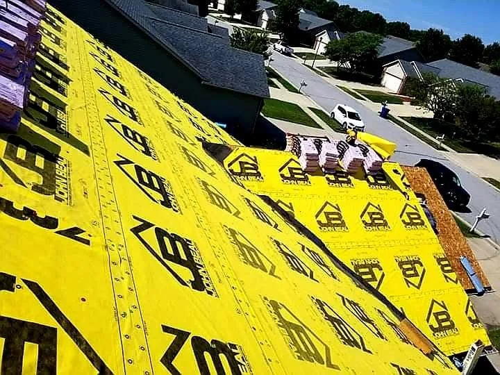 Residential roof mid-replacement with underlayment and shingle bundles staged